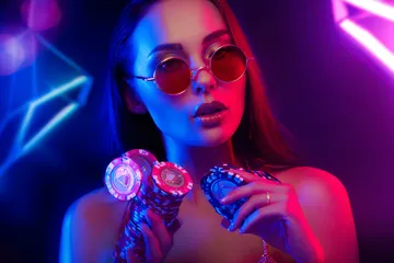 A woman smiling by bright slot machines showing lucky symbols, showcasing the exciting slot offerings at JL777.
